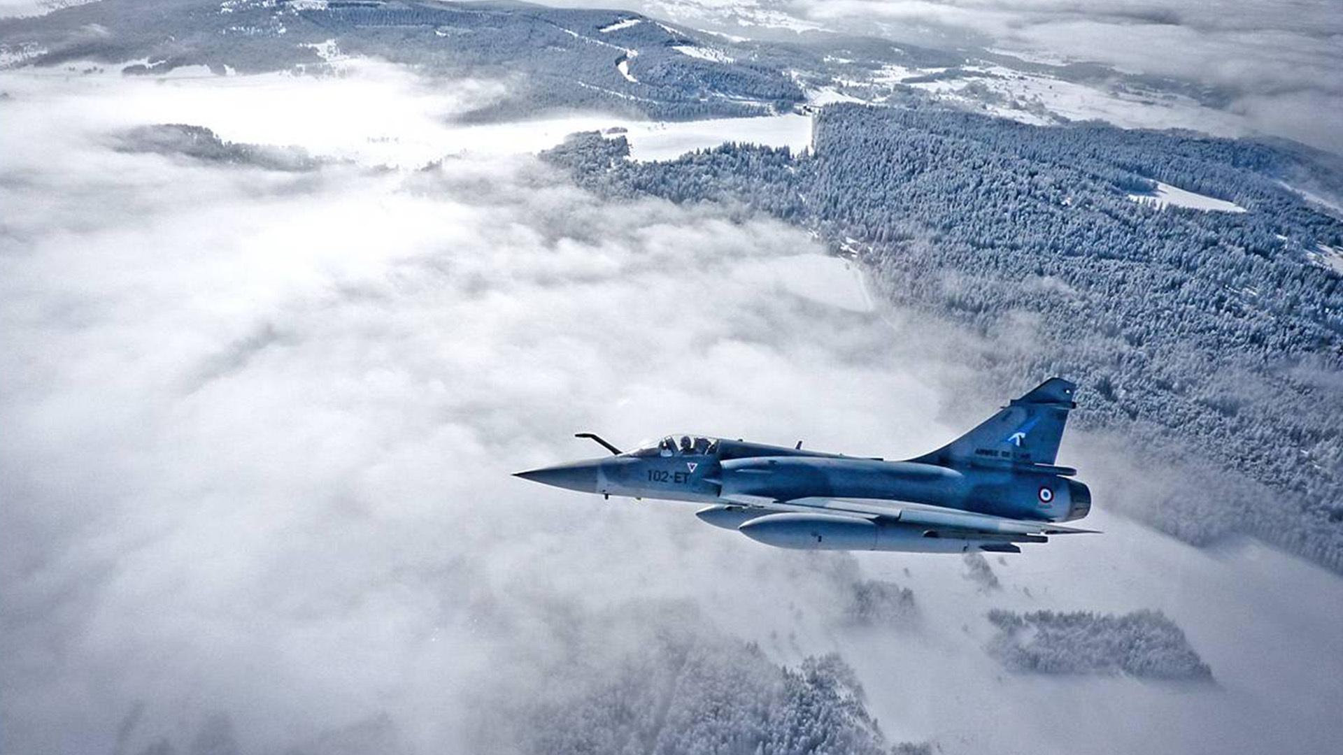French mirage fighter plane over forest in winter -