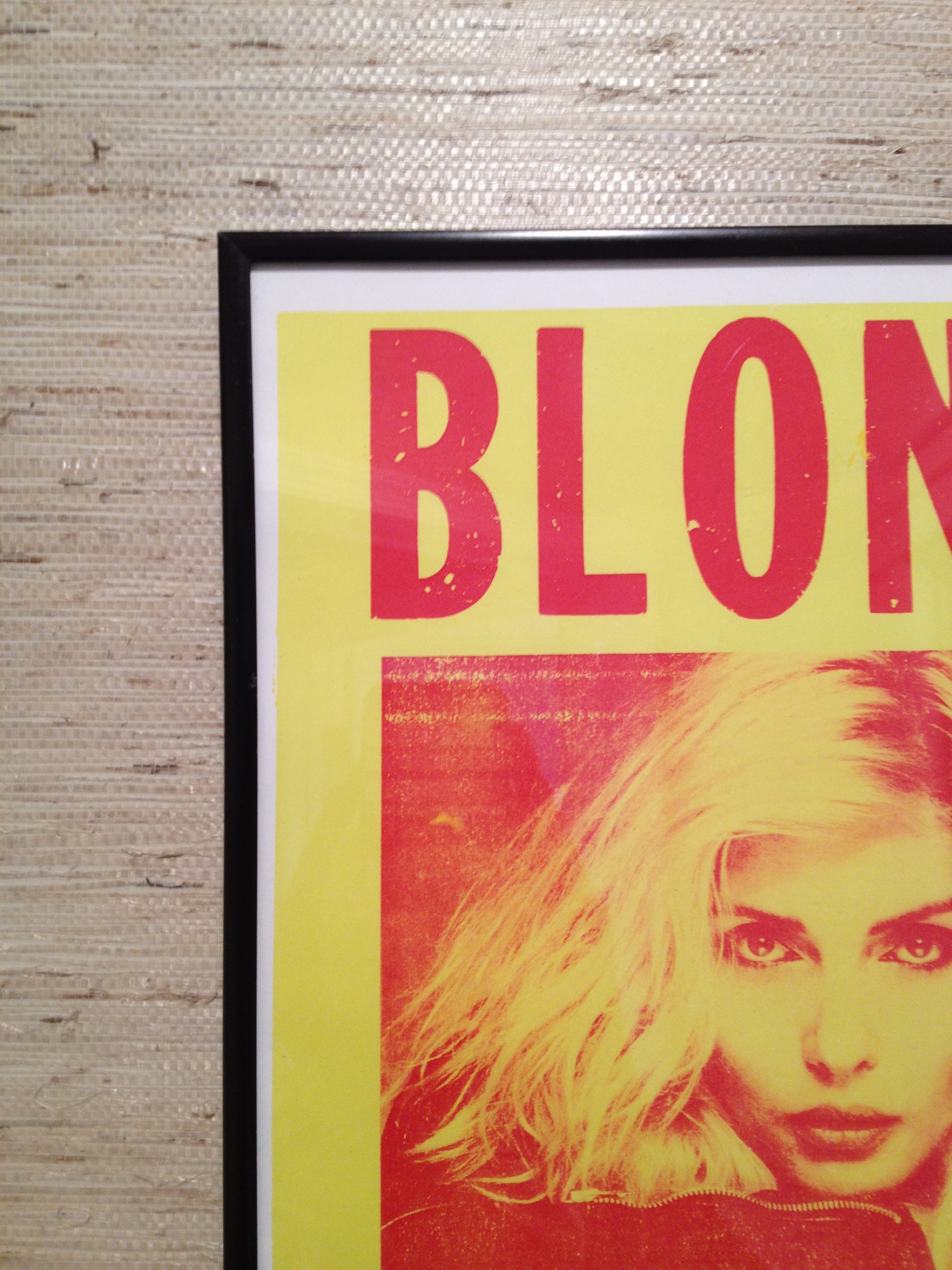 Blondie poster against the grass cloth wallpaper in bathroom